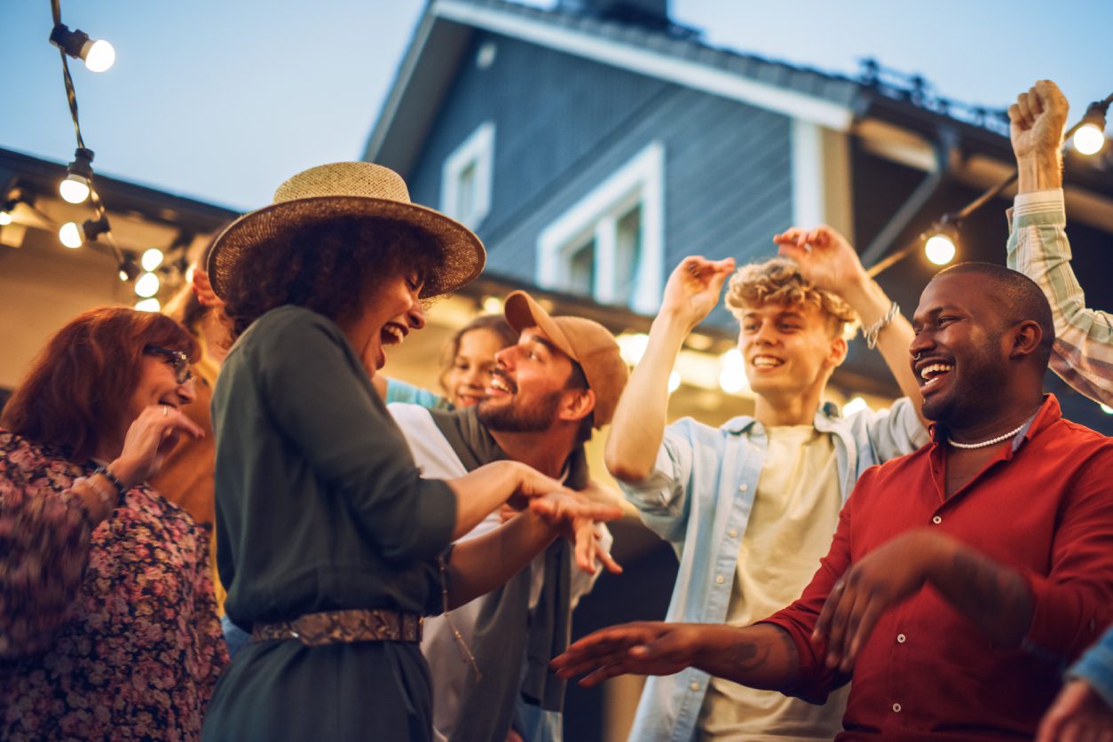 Group of friends dancing at outdoor party.
